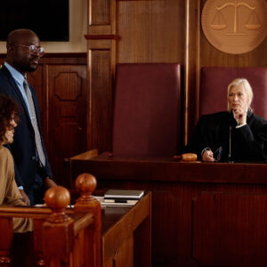 Confident experienced female judge sitting in front of elegant attorney