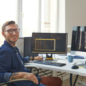 Portrait of IT Programmer Using Computers with Code on Screen