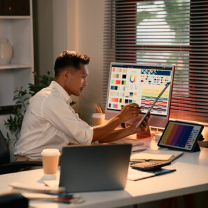Focused graphic designer working on color palettes and digital layouts in a modern office