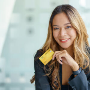 Asian businesswoman smiling and looking at camera in hand holdin